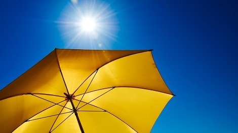 Yellow Umbrella With Bright Sun And Blue Sky